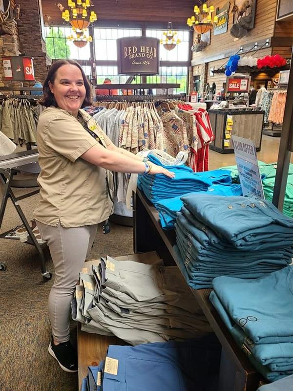 Person folding clothes smiling looking off into the distance