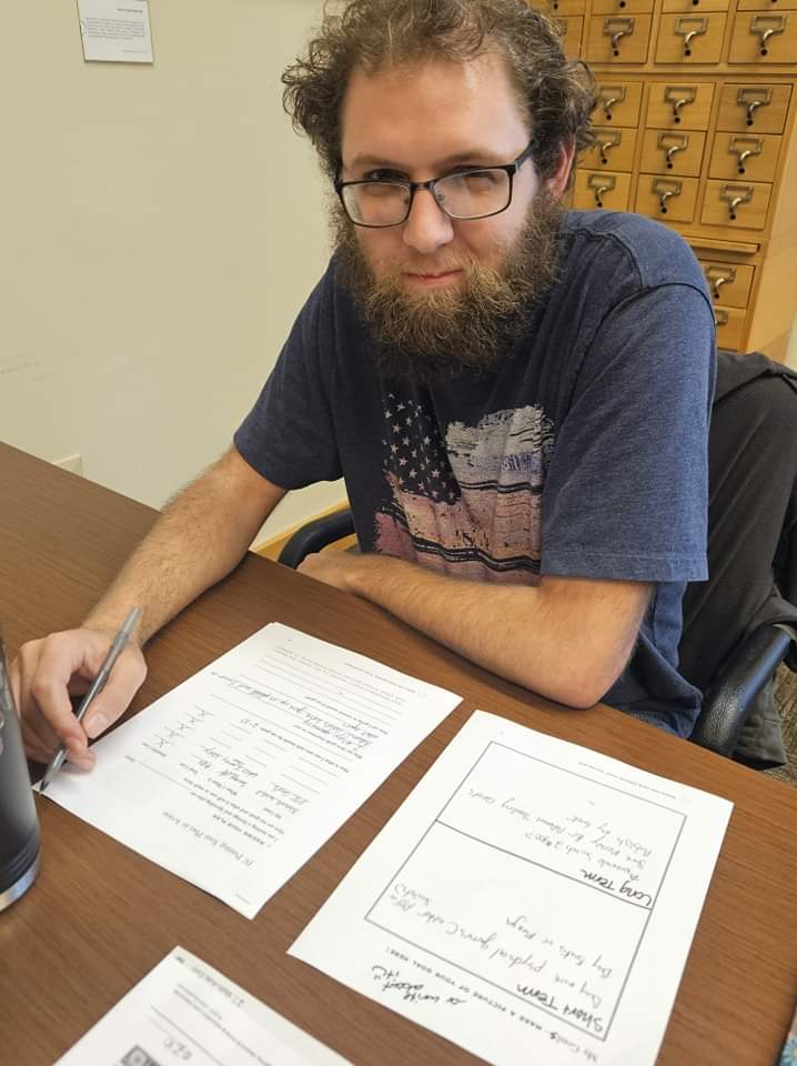 Person sitting at a desk filling out paperwork