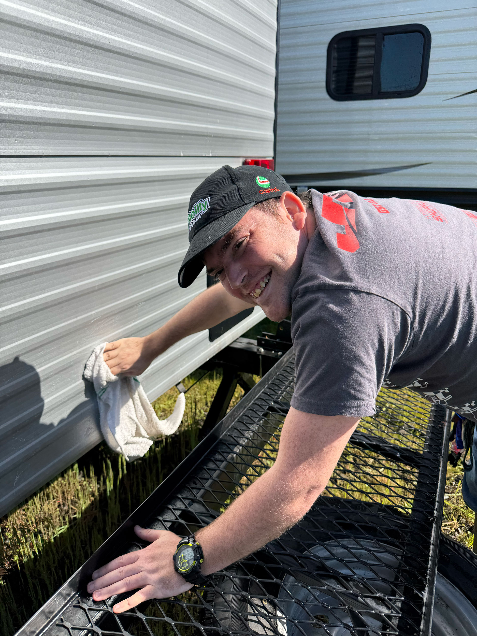 A person cleaning an RV smiling at the camera